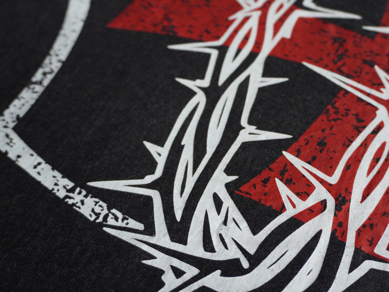 Close-up of the red and white Thorn Bearer artwork printed across the back of the acid wash black tee.
